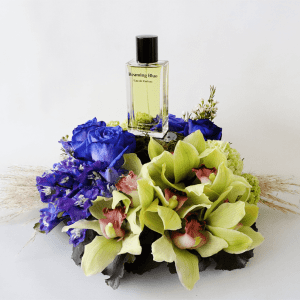Cymbidium orchids with blue rose and delphinium in an arrangement with beaming blue perfume