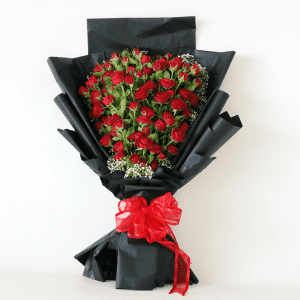 Red spray roses arranged in a heart shape with black paper