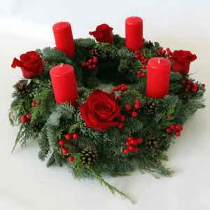 round wreath with four pillar candles and red roses