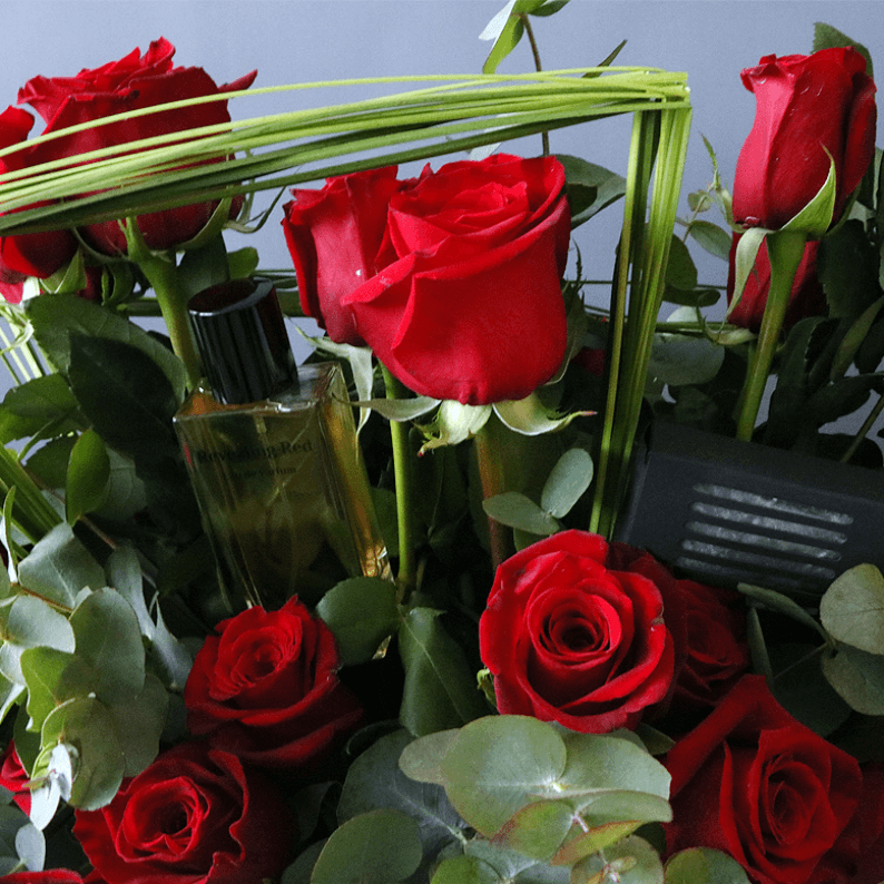 closes up of revealing red perfume with red roses