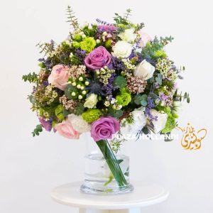 pink, purple, green and white flower arrangement in a glass vase