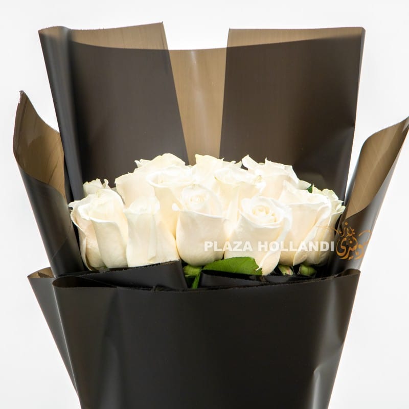 close up of white roses and black wrapping bouquet