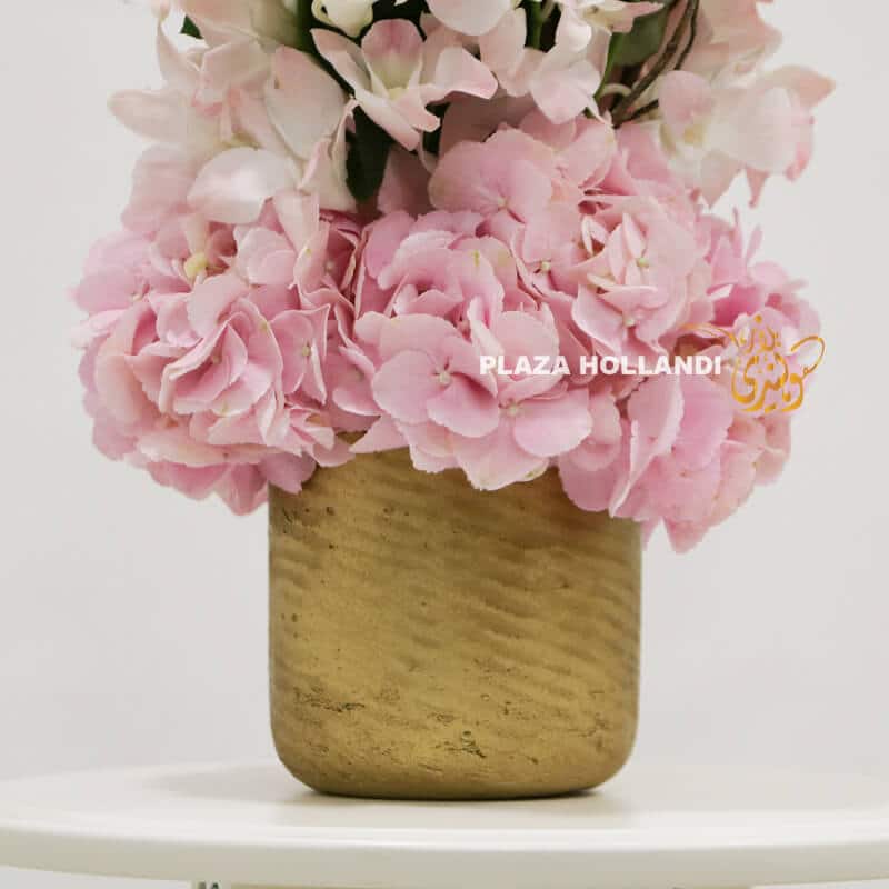 Close up of pink flower arrangement with gold pot