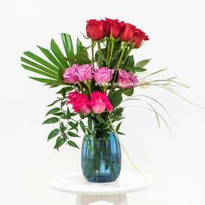red, purple and pink roses in a blue vase