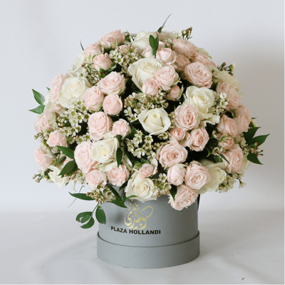 peach and pink spray roses in a round design in a hat box