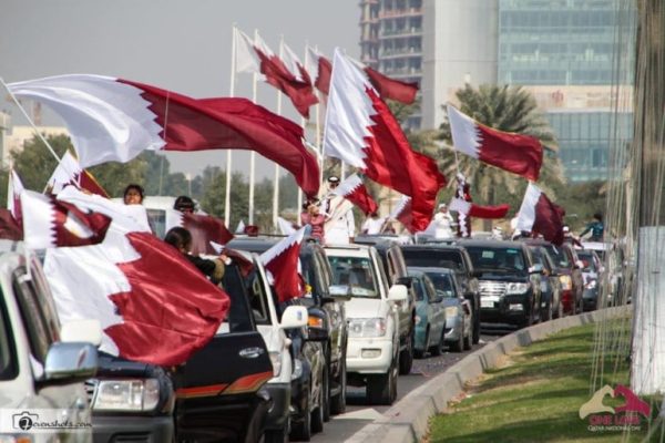 qatar national day parade with cars and qatari flag